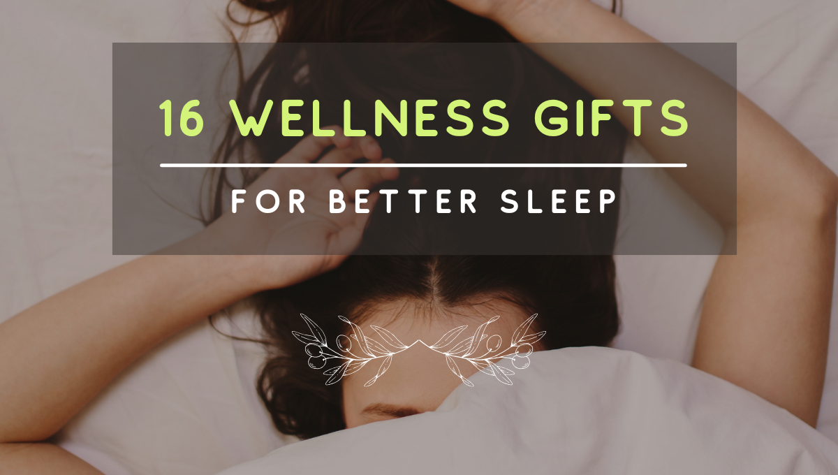 Woman resting under white bedding with text overlay ā16 Wellness Gifts for Better Sleepā ā cozy, calming image promoting Olive + Crateās sleep gift guide.