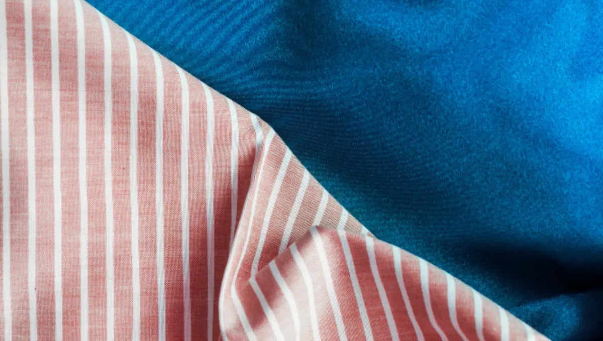Close-up of two bedding fabrics showing a striped natural-looking textile beside a smooth synthetic blue fabric for texture comparison.