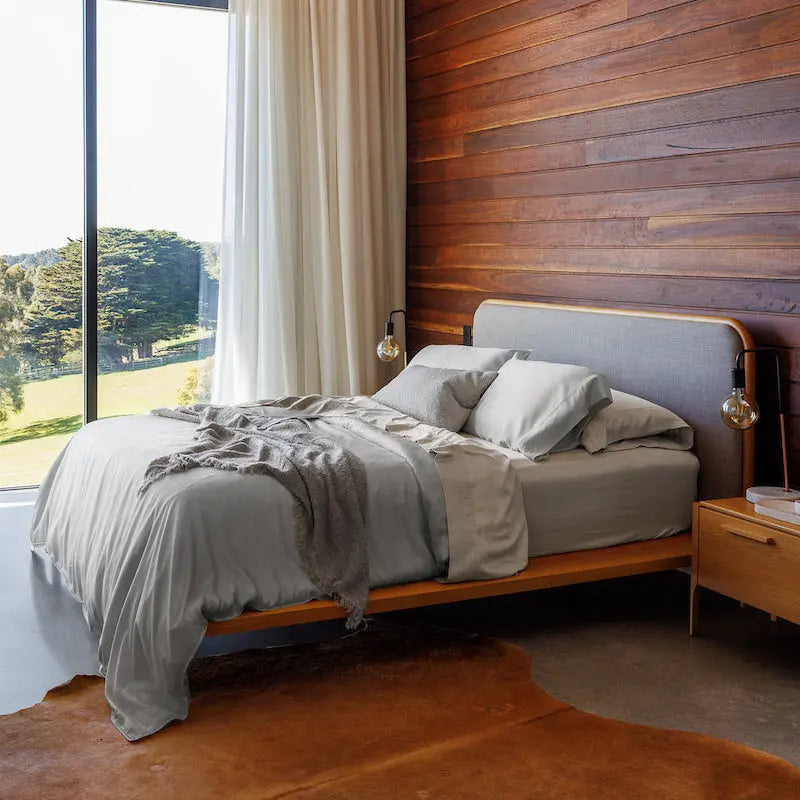 Modern bedroom with wooden wall, bed, and large window.