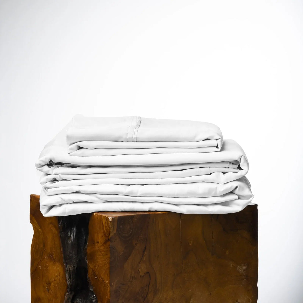 Stack of white folded towels on a wooden block against a white background #color_white snow