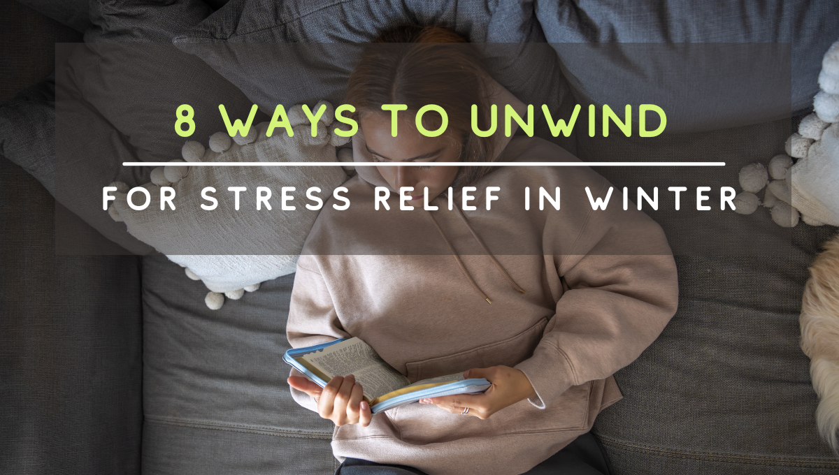 Person relaxing on a sofa reading a book, illustrating cozy winter stress relief and evening unwinding.