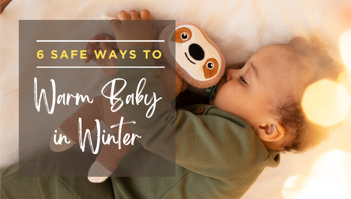 Baby sleeping on a bed while cuddling a plush sloth toy, with warm golden light in the background and an overlay text reading “6 Safe Ways to Warm Baby in Winter.”