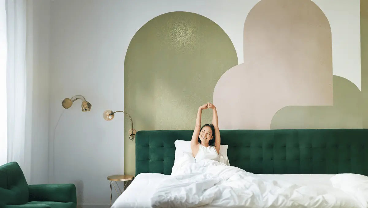 Bright modern bedroom with crisp white bedding as a woman stretches in bed, creating a refreshed and restful space.