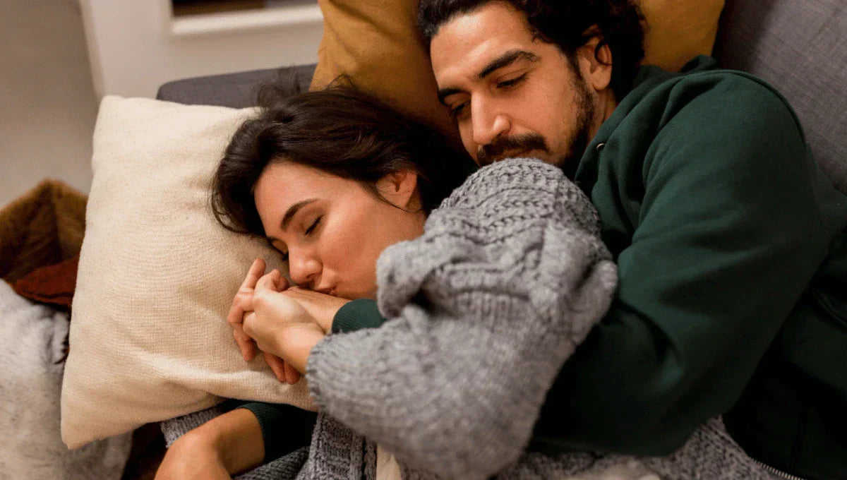 Couple cuddling in bed demonstrating the benefits of cuddling for sleep and emotional connection.