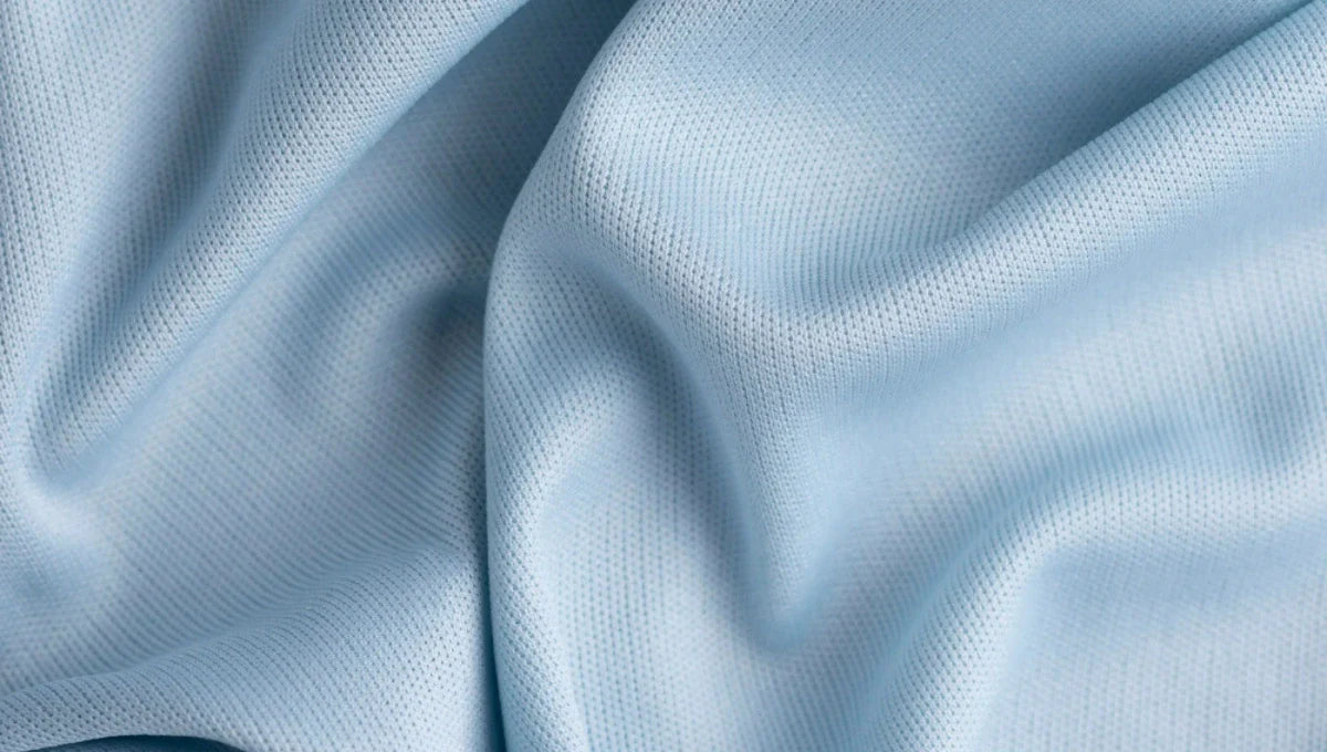 Close-up of soft light blue rayon fabric with a smooth breathable texture and gentle folds.