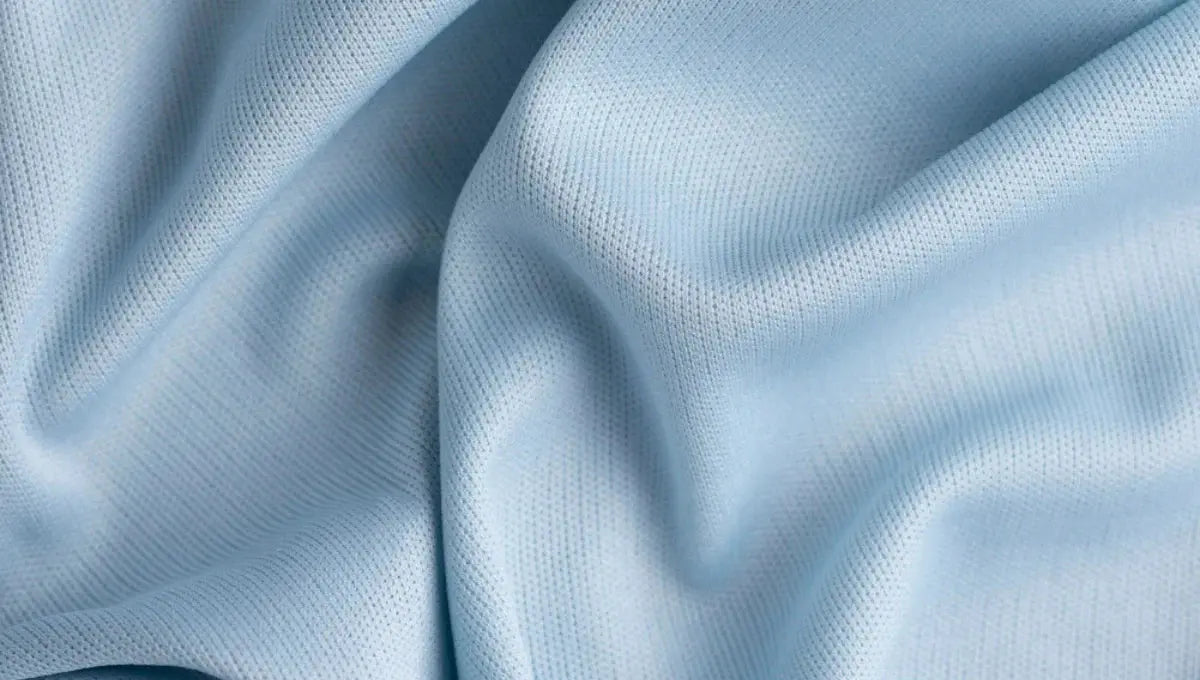 Close-up of soft light blue rayon fabric with a smooth breathable texture and gentle folds.