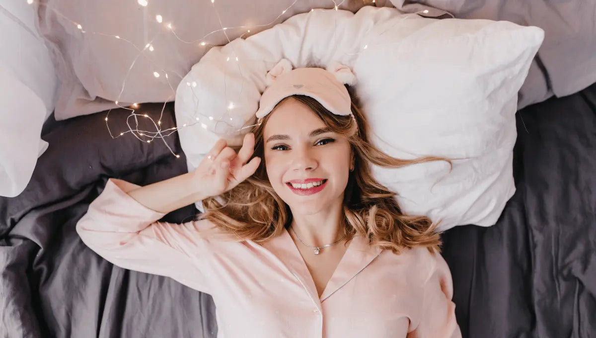 Cozy winter bedroom scene with warm lighting, soft blankets, and a mug, creating a calm atmosphere for better sleep.