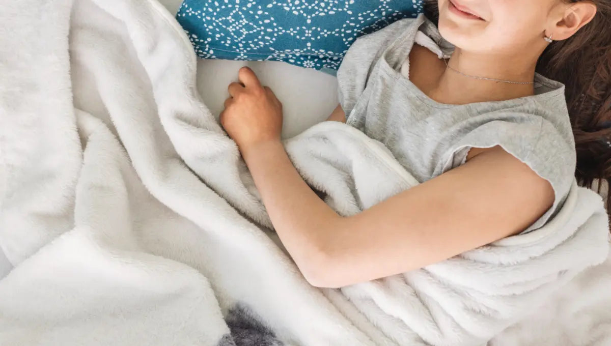 Teen resting comfortably under a soft blanket to support healthy sleep during adolescence.