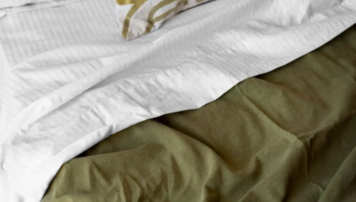White vegan silk-style bedding layered over eucalyptus lyocell sheets on a bed.