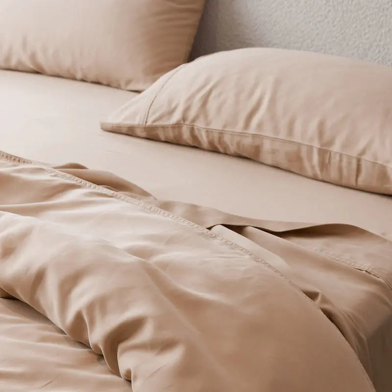 Terracotta bedding set on a bed with pillows. 