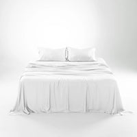 White bedding set on a bed with a plain background #color_white snow